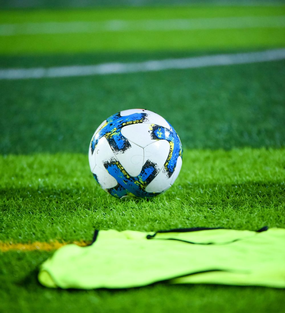 Vibrant soccer field scene featuring a ball and training gear on well-maintained turf.